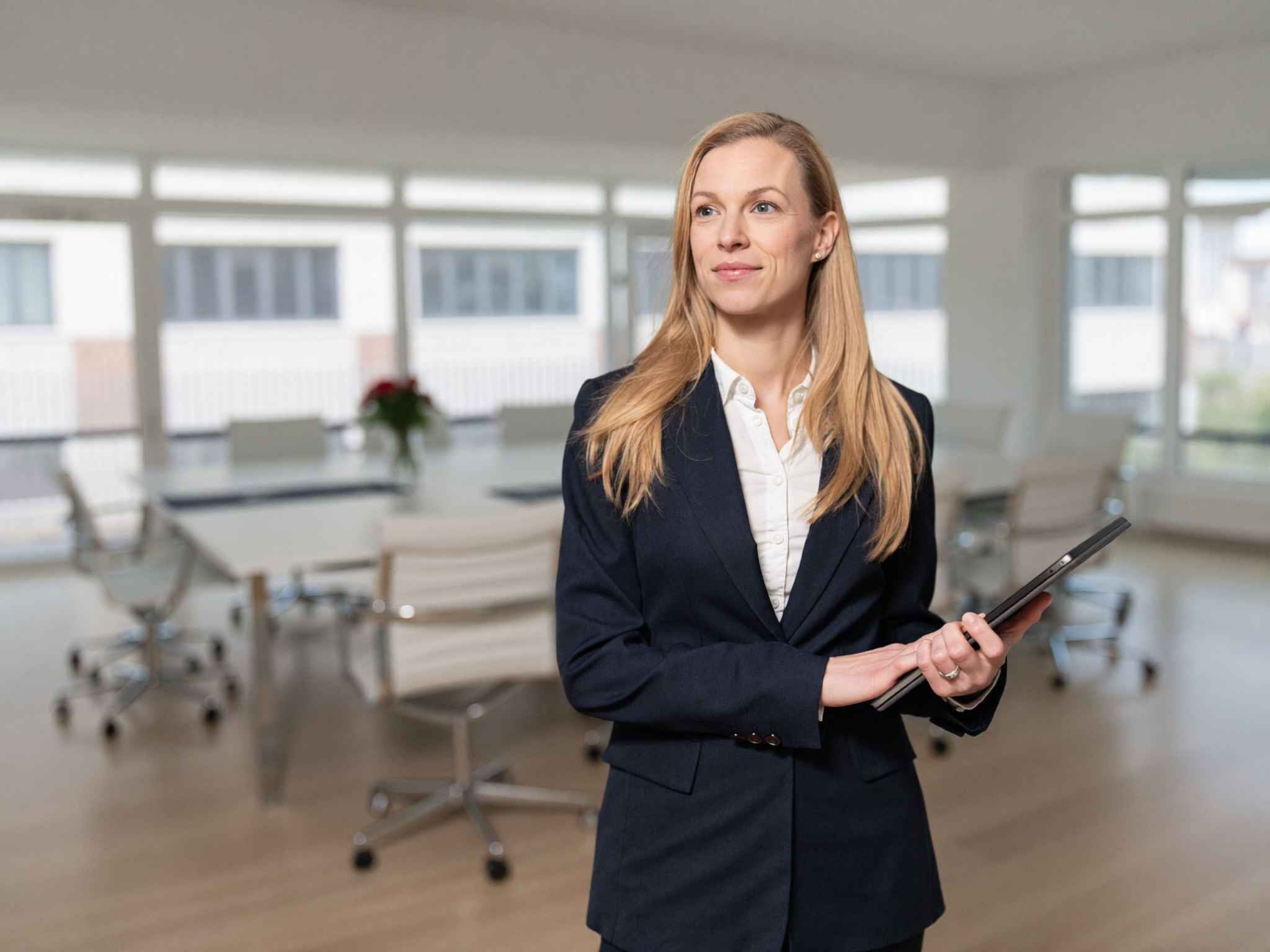 Katharina Heid mit Tablet in einer modernen Bürofläche.