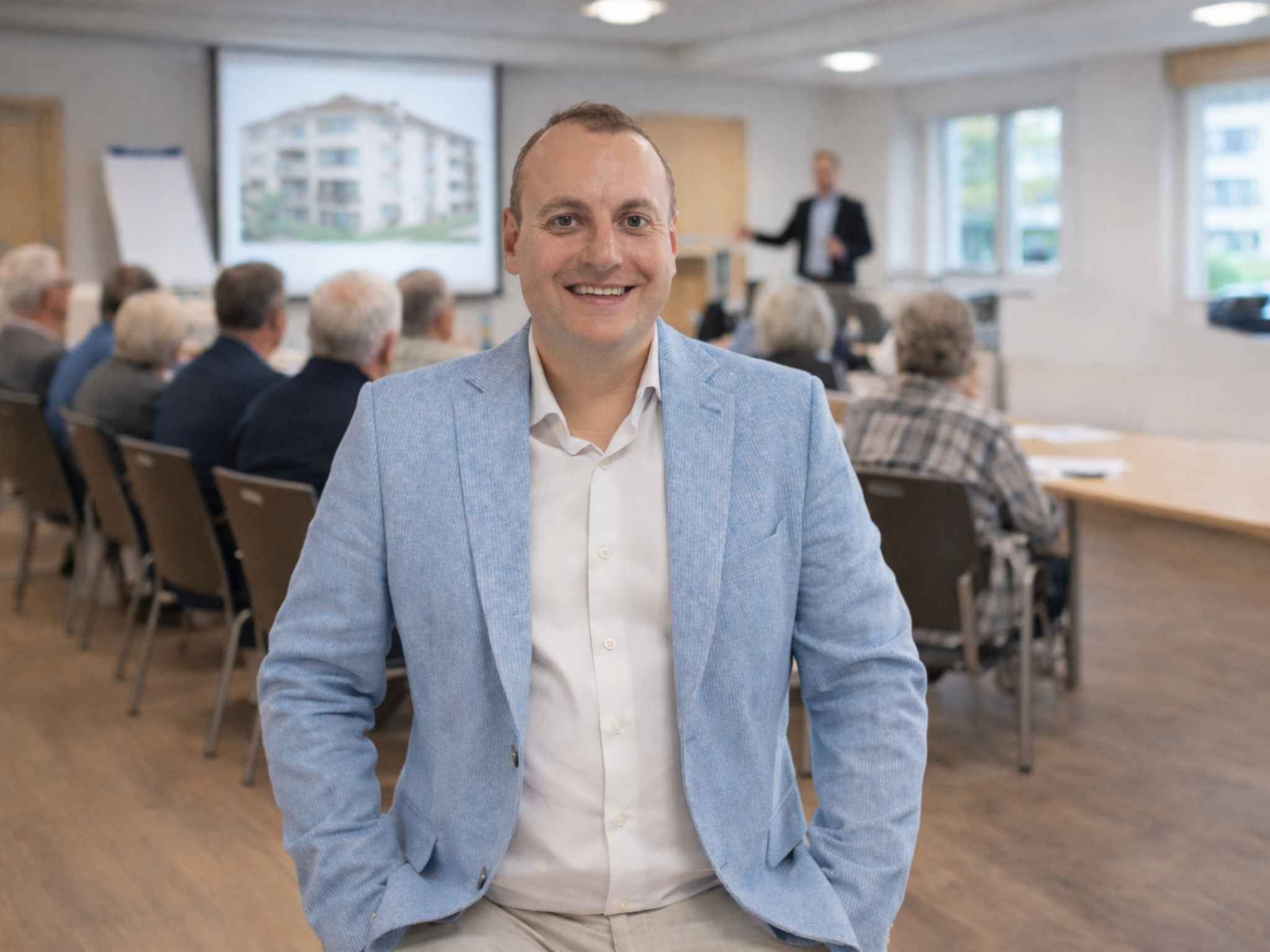 André Heid mit der Eigentümergemeinschaft eines Mehrfamilienhauses im Hintergrund