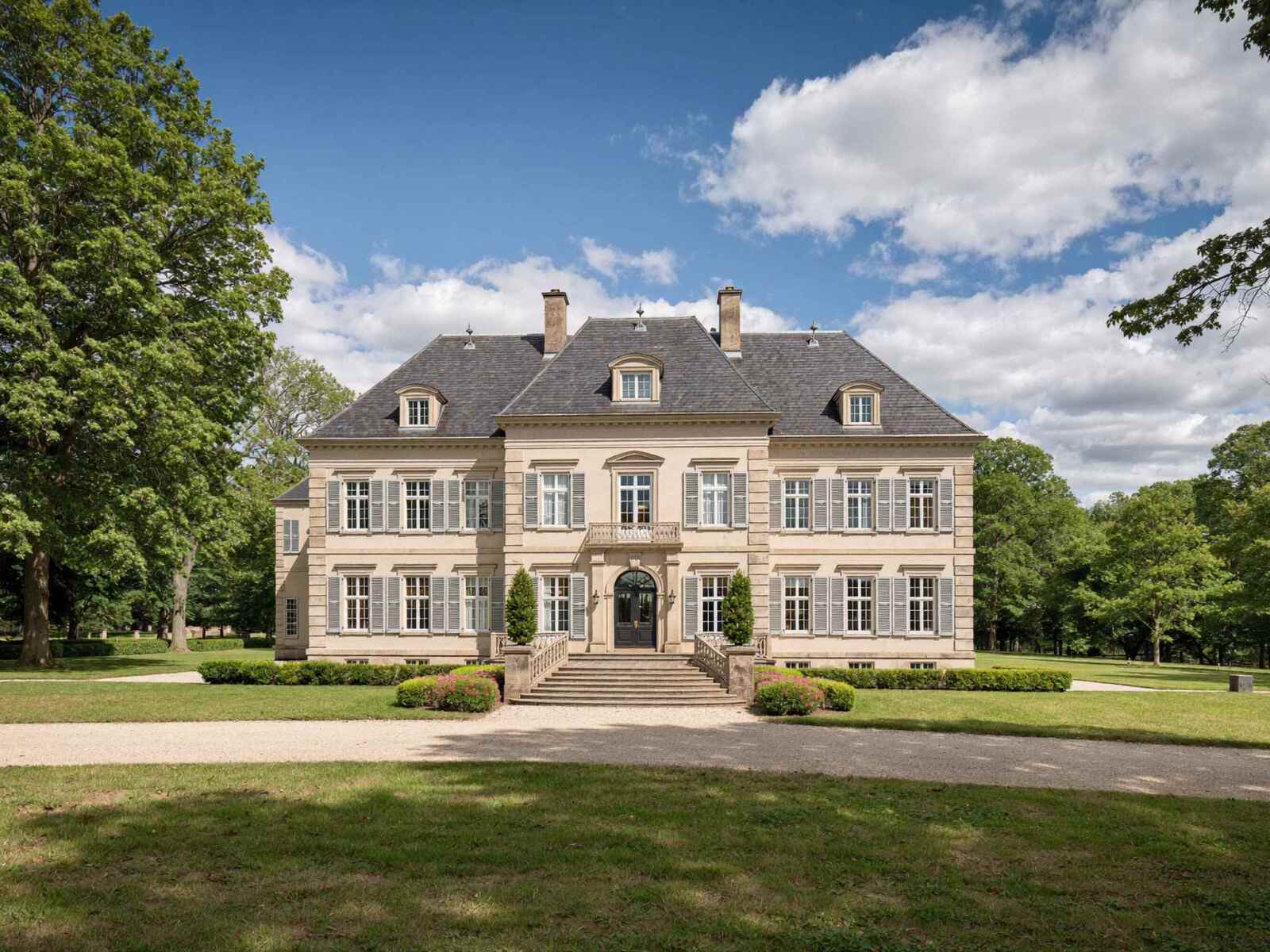 Historisches Herrenhaus mit repräsentativer Fassade und großer Parkanlage.